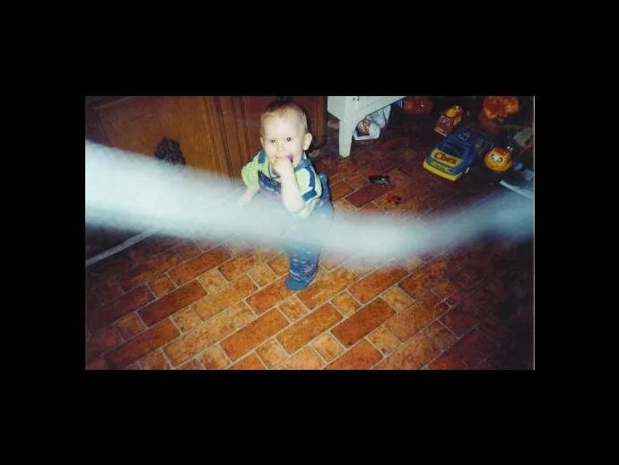 Infant picture with a possible vortex (or strap?) running across the middle of the photo?