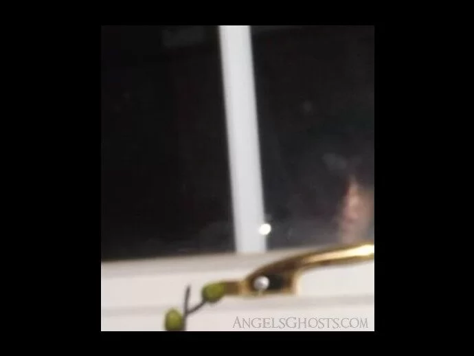 Could this be the glimpse of a young, male ghost in the window or a reflection?