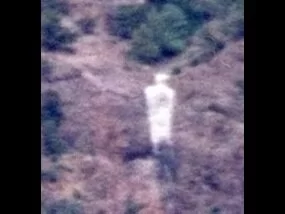 The picture shows a human form, possibly a desert spirit, of someone walking a trail.