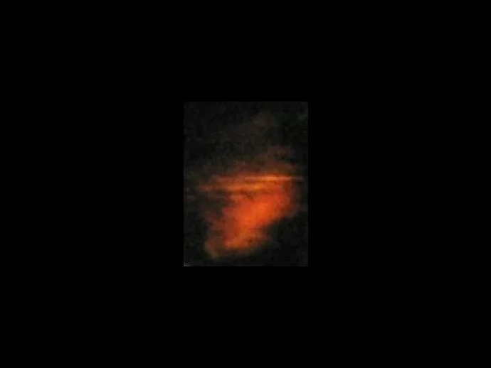 Lightened close-up of the area with the orange glow. Do you see the two faces near the top?