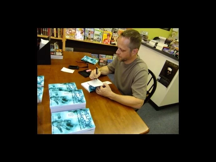 Author Louis Charles signing copies of Helping Ghosts at Backlist Books in Massillon, Ohio, June 24, 2010.