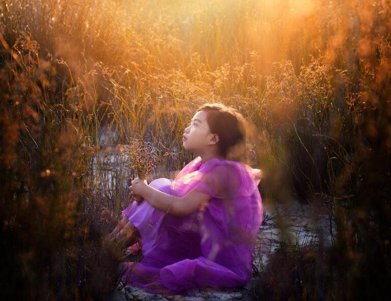 Spiritual Awakening in Children a little girl in a purple dress sitting in a field